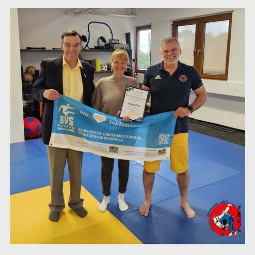 Drei Personen halten Banner und Urkunde